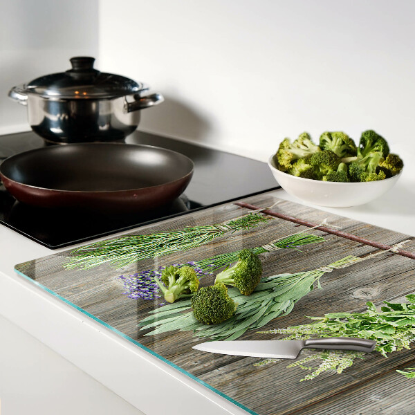 Szklana deska kuchenna z motywem ziół na tle drewnianym