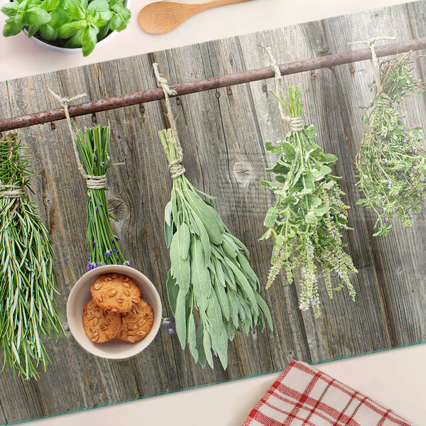 Szklana deska kuchenna z motywem ziół na tle drewnianym