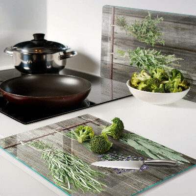 Szklana deska kuchenna z motywem ziół na tle drewnianym