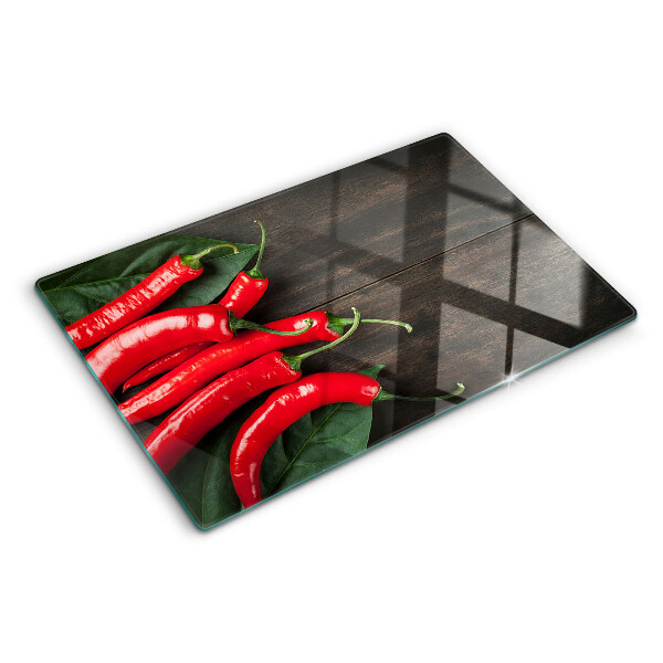 Szklana deska do krojenia z nadrukiem papryczek chili na tle drewnianego blatu