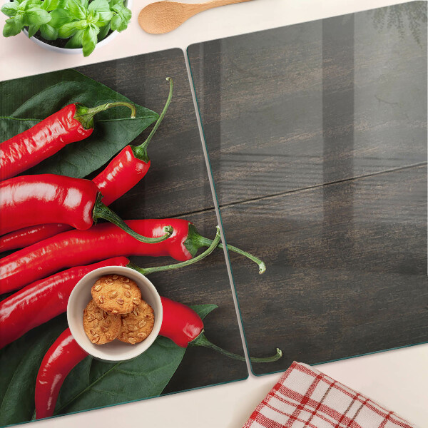 Szklana deska do krojenia z nadrukiem papryczek chili na tle drewnianego blatu