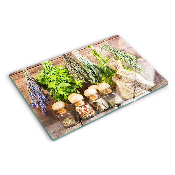 Szklana deska do krojenia z motywem ziół i przypraw na tle drewna