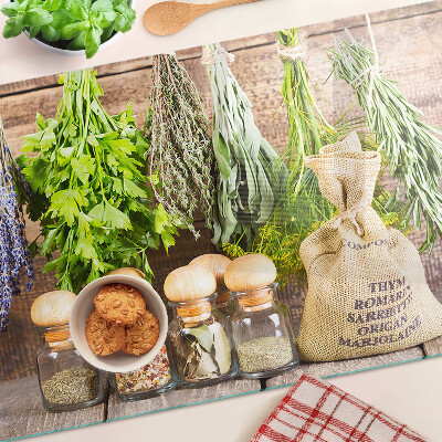 Szklana deska do krojenia z motywem ziół i przypraw na tle drewna