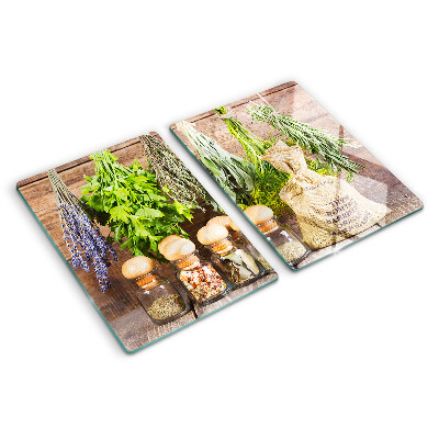 Szklana deska do krojenia z motywem ziół i przypraw na tle drewna