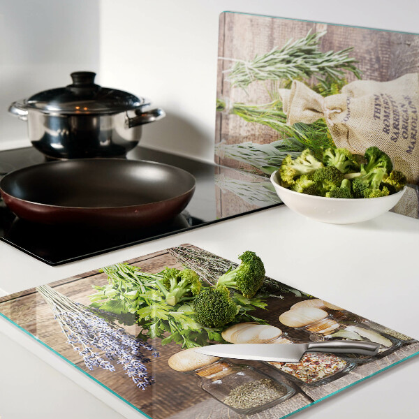 Szklana deska do krojenia z motywem ziół i przypraw na tle drewna