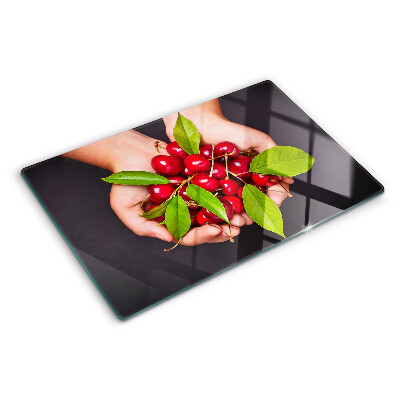 Szklana deska do krojenia z motywem czerwonych wiśni trzymanych w dłoniach