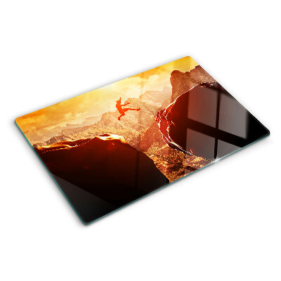 Szklana deska kuchenna z motywem skoku w górach przy zachodzie słońca
