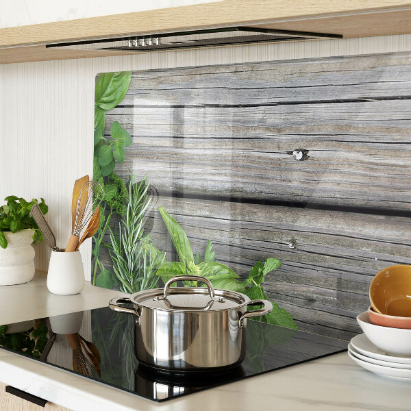 Szklana deska kuchenna z motywem zielonych ziół na drewnianym tle