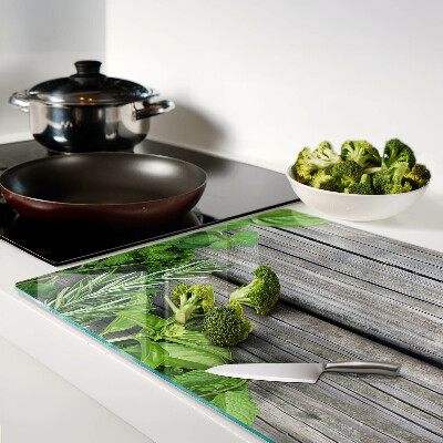 Szklana deska kuchenna z motywem zielonych ziół na drewnianym tle