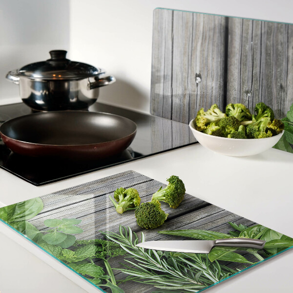 Szklana deska kuchenna z motywem zielonych ziół na drewnianym tle