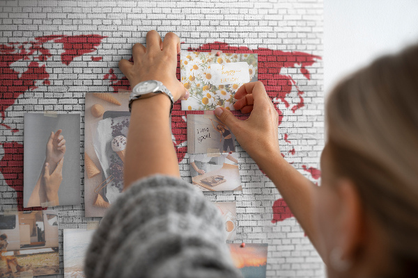 Tablica korkowa z nadrukiem Czerwony kontur świata na ceglanej ścianie